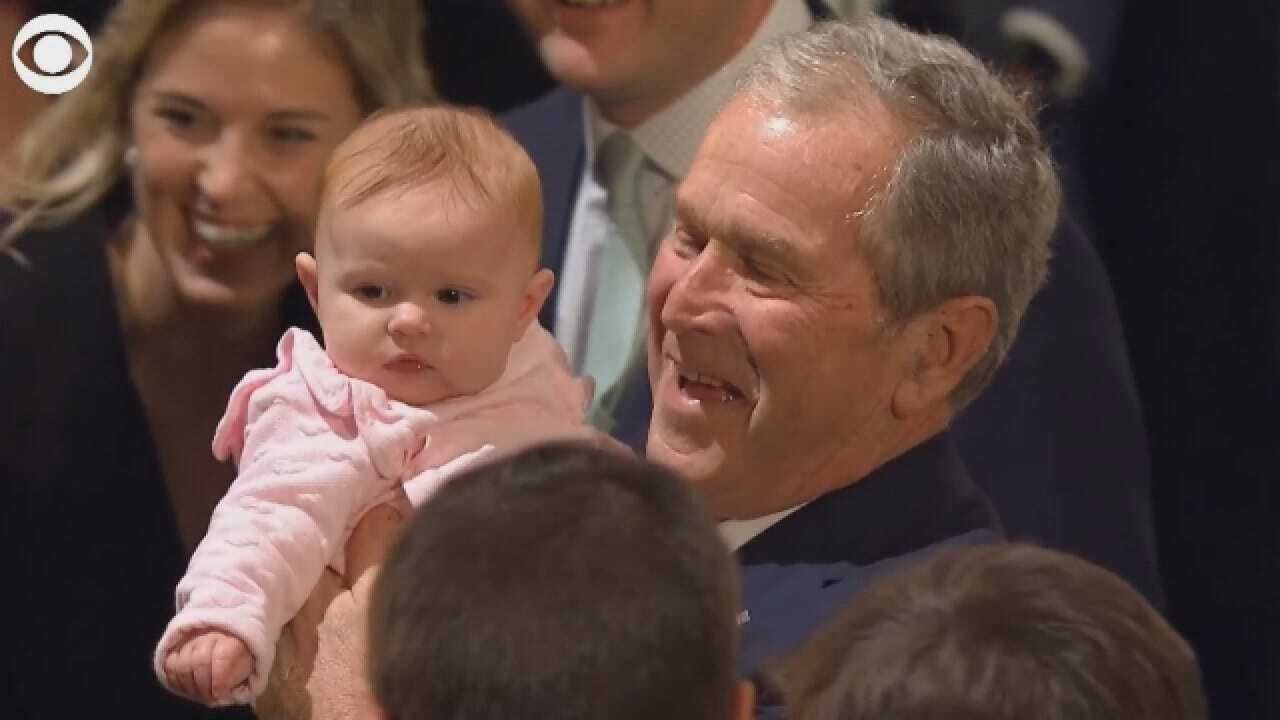 George W. Bush Holds The Baby Of A Mourner Honoring His Father